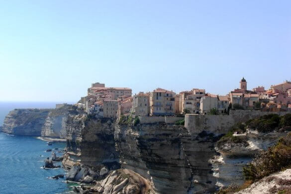Maisons colorées de Bonifacio posées sur une falaise au-dessus de la Méditerranée.