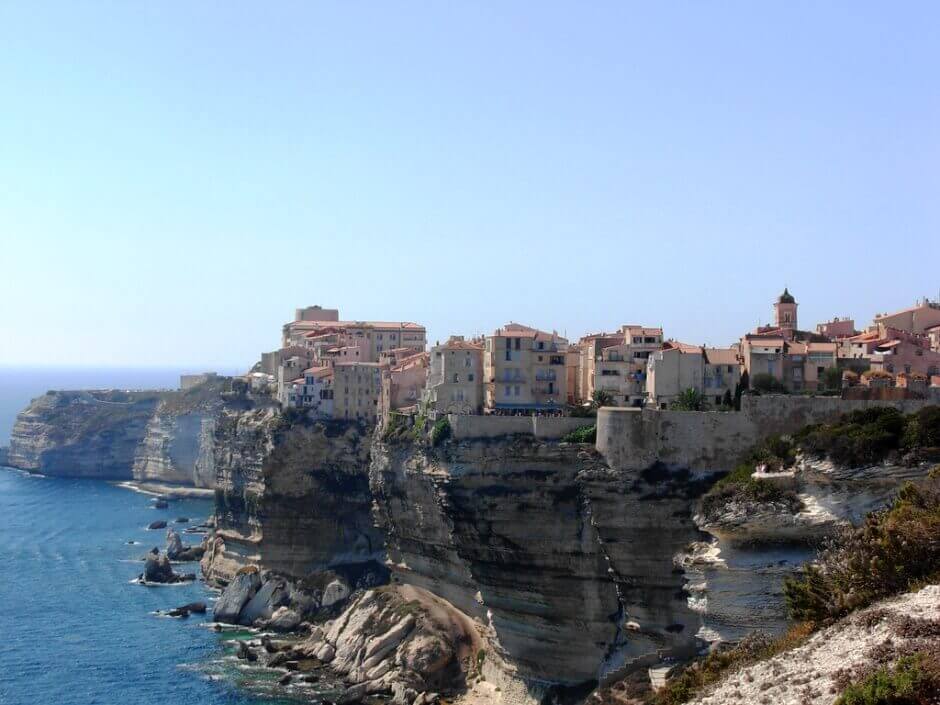 Maisons colorées de Bonifacio posées sur une falaise au-dessus de la Méditerranée.