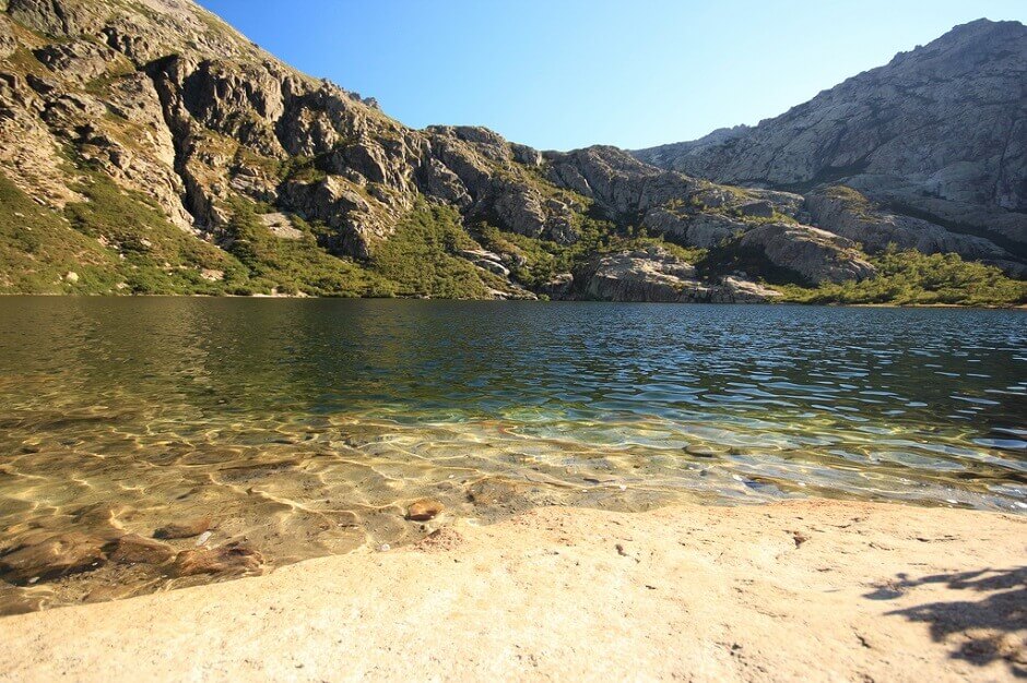 Vue d'une plage au bord d'un lac de montagne en Corse.