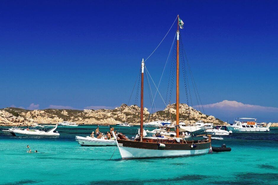 Des bateaux amarrés dans un mer transparente en Sardaigne.