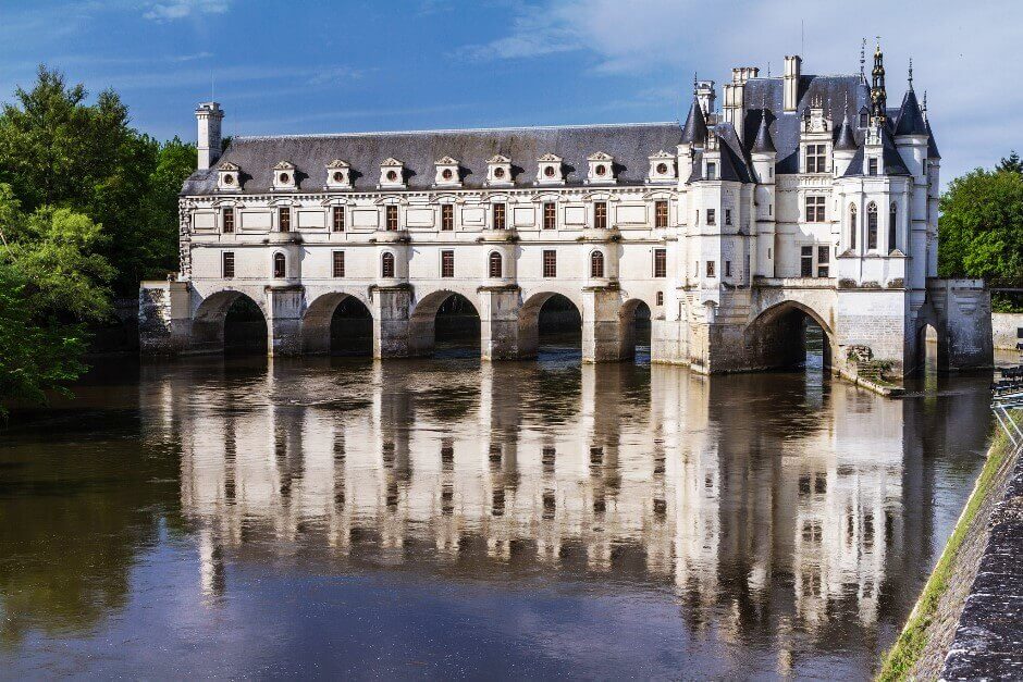 Vue d'un château construit comme un pont au-dessus d'une rivière.