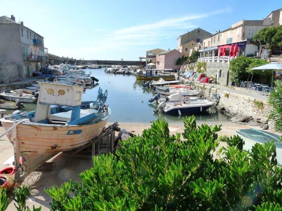 Vue d'un petit port avec des barques dans un village corse.