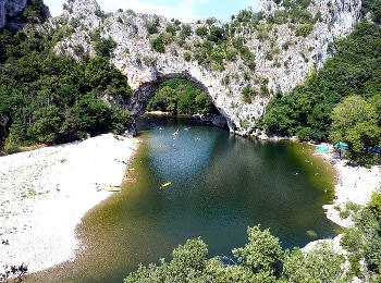 Canoes passant sous une arche rocheuse.