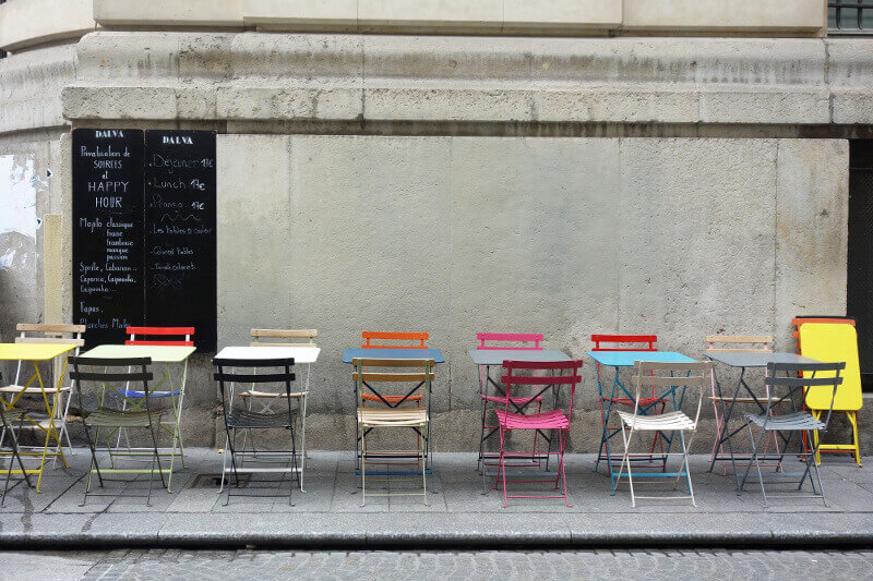 Tables et chaises colorées d'un café à Paris.