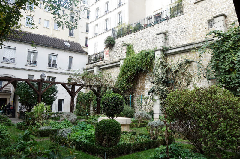 Jardin au cœur des maisons de Montmartre, à Paris.