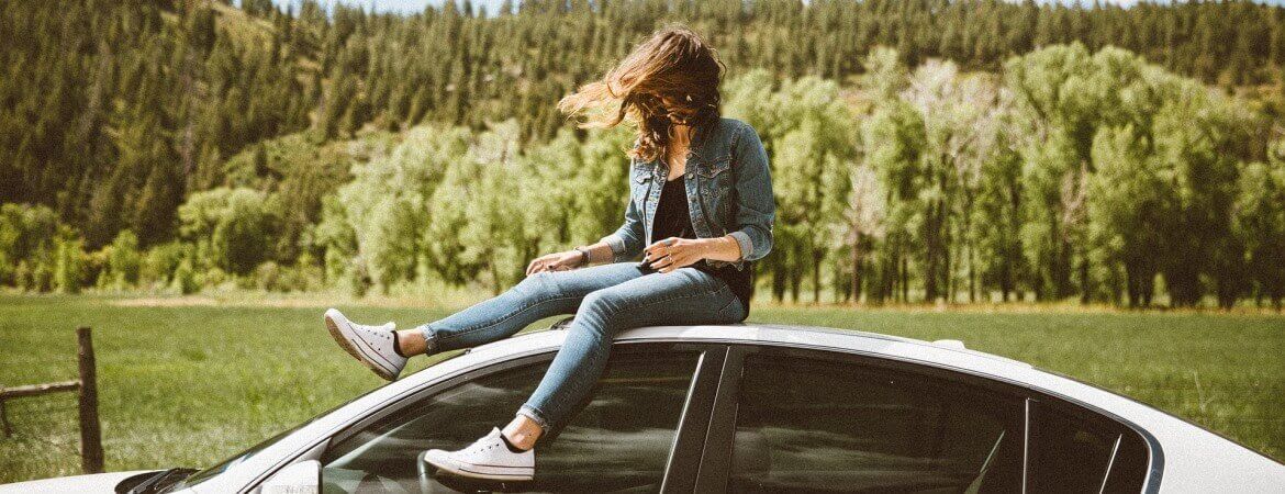 Femme sur le toit d'une voiture.