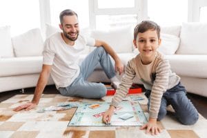 père et fils jouant au Monopoly