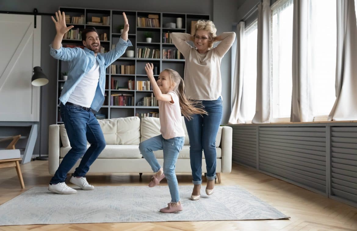 parents dansant avec leur fille dans le salon