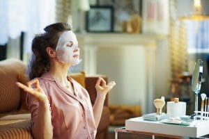 femme se relaxant avec un masque de beauté