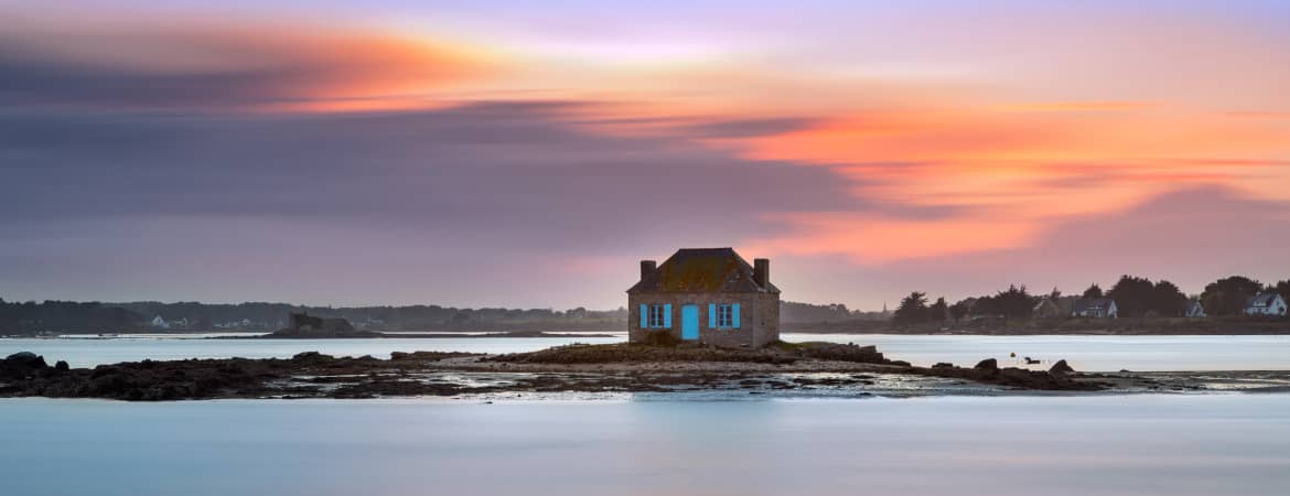 Une maison sur un îlot en Bretagne au soleil couchant.