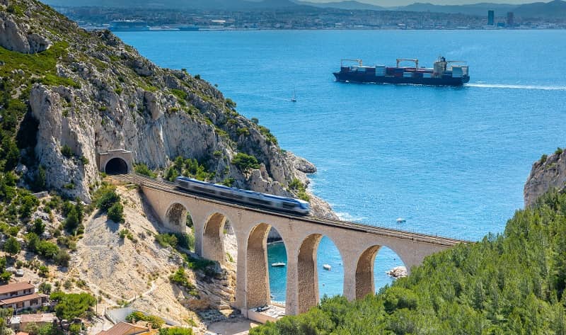 Vue d'un train sur un pont au bord de la mer.