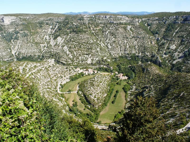 Vue d'une vallée au pied d'une montagne rocheuse.