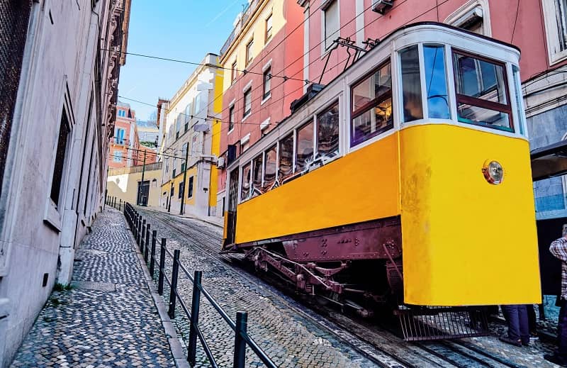 Vue d'un tramway jaune dans une rue en pente.